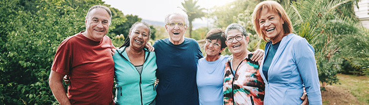 Two older men and four older women smiling with their arms around each other Two older men and four older women smiling with their arms around each other