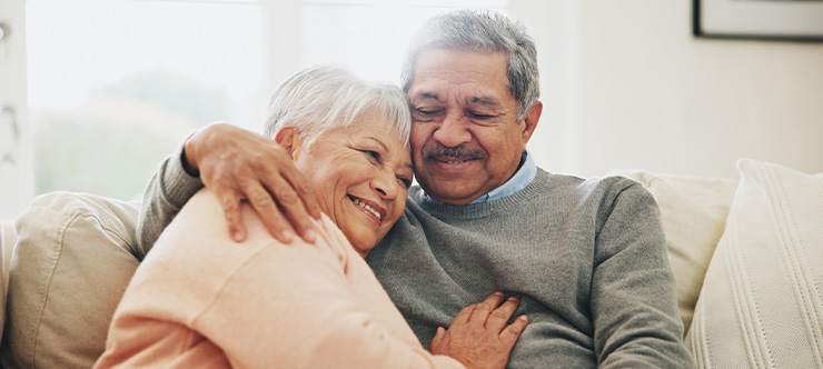 Image of an older couple hugging on couch Image of an older couple hugging on couch